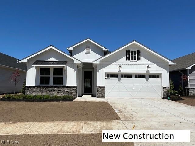 2180 Myla Way, Amherst, OH 44001 - modern farmhouse style home with stone siding, a garage, board and batten siding, and driveway
