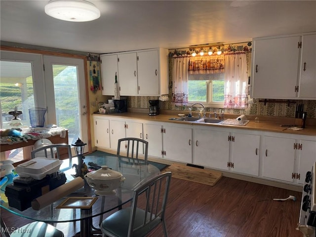 kitchen with white cabinets, decorative backsplash, dark hardwood / wood-style floors, and sink