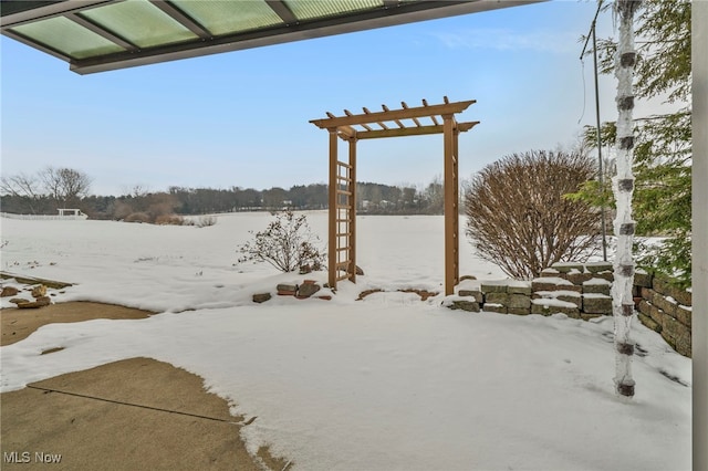 yard layered in snow featuring a water view