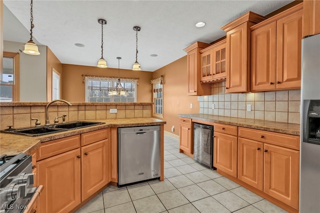 kitchen with sink, light tile patterned floors, hanging light fixtures, and appliances with stainless steel finishes