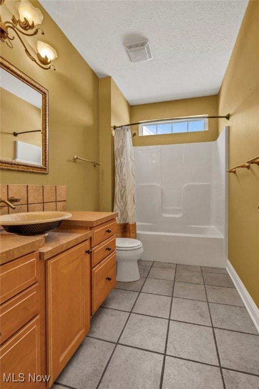 full bathroom with shower / bath combo, tile patterned floors, a textured ceiling, toilet, and vanity