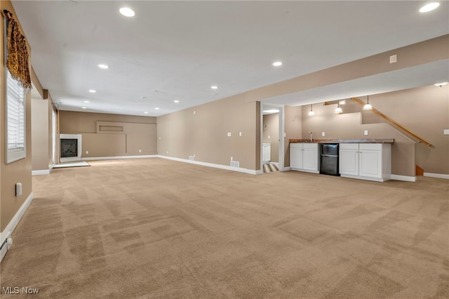 unfurnished living room featuring light carpet and wet bar