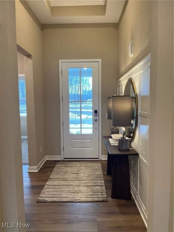 doorway to outside featuring dark hardwood / wood-style floors and a tray ceiling