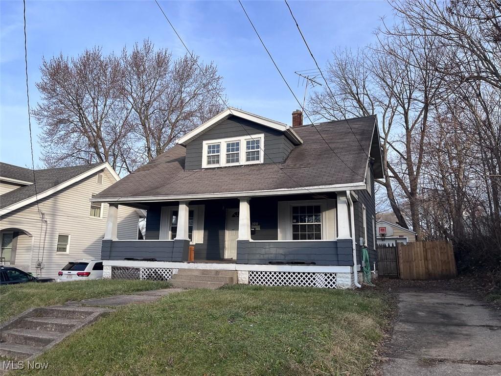 bungalow featuring covered porch and a front yard