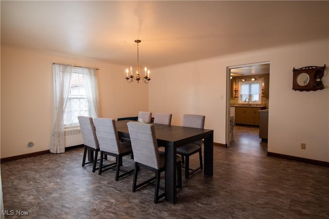 dining space featuring a chandelier, radiator heating unit, and baseboards