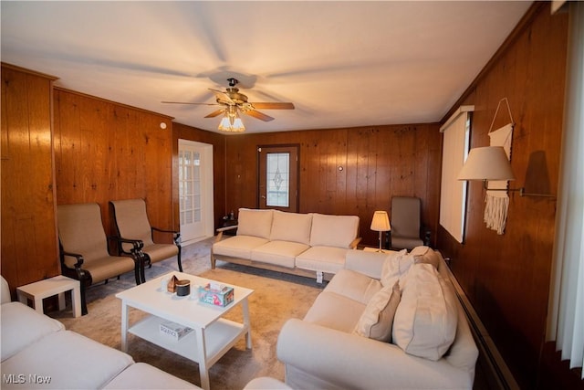 living area with a ceiling fan and wooden walls