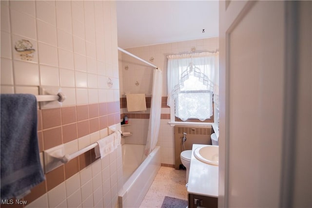 full bathroom with toilet, shower / tub combo with curtain, tile walls, and vanity