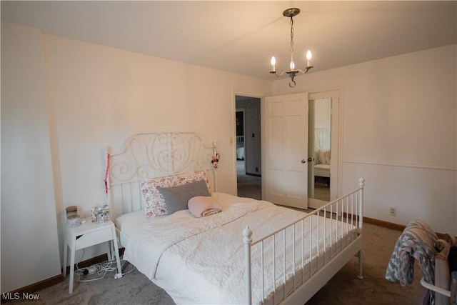 carpeted bedroom featuring an inviting chandelier and baseboards