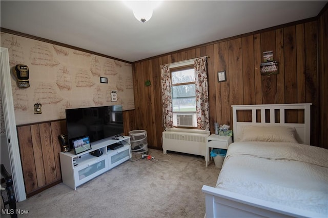 bedroom with crown molding, a wainscoted wall, light colored carpet, and radiator