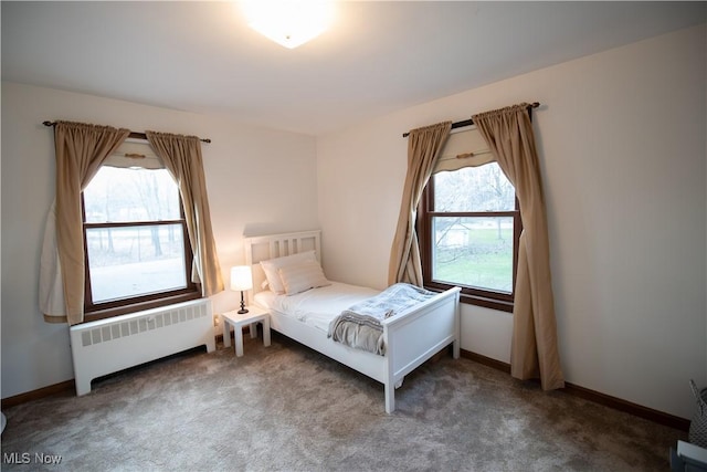 unfurnished bedroom featuring radiator, carpet, and baseboards