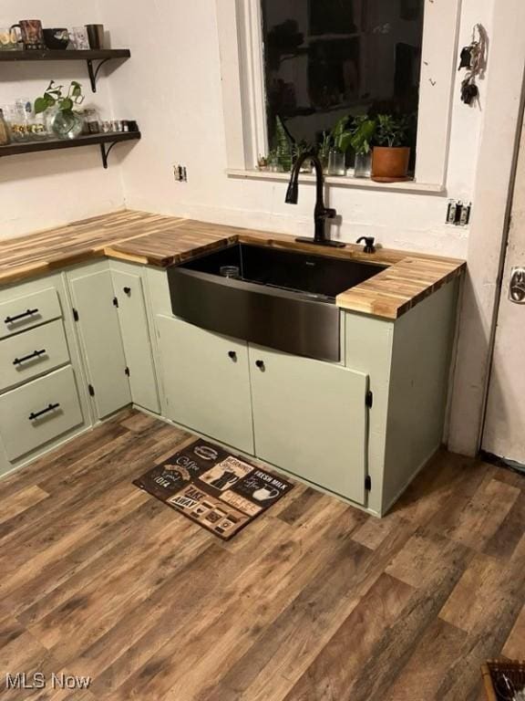 bar featuring green cabinets, butcher block counters, sink, and dark wood-type flooring