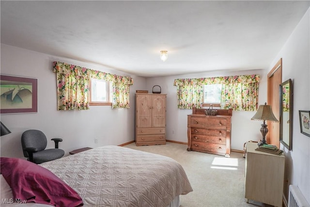 bedroom with light carpet and multiple windows