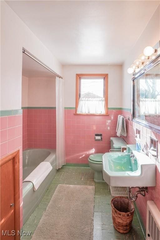 full bathroom featuring sink, toilet, tile walls, and radiator