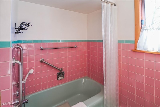 bathroom with shower / bath combination with curtain and tile walls