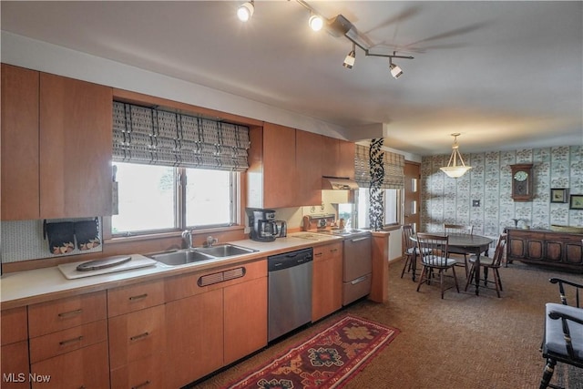 kitchen featuring dishwasher, range, decorative light fixtures, and sink