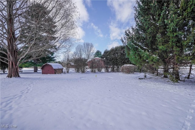 yard layered in snow featuring an outdoor structure