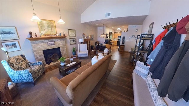 living room with a fireplace, high vaulted ceiling, and dark wood-type flooring