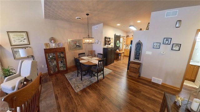 dining area featuring dark hardwood / wood-style flooring and an inviting chandelier