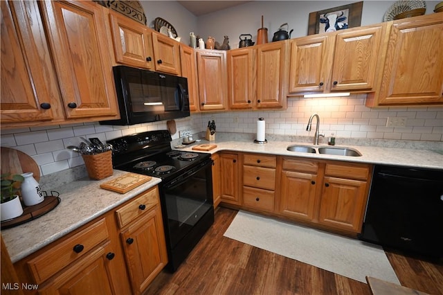 kitchen featuring black appliances, dark wood-type flooring, sink, and tasteful backsplash