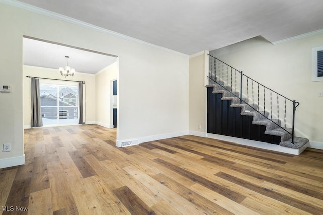 entrance foyer with crown molding, an inviting chandelier, and hardwood / wood-style flooring