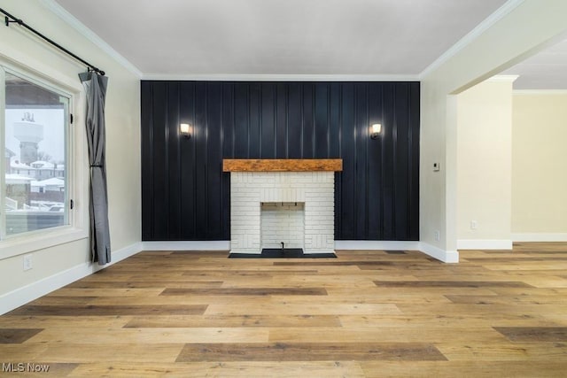 unfurnished living room featuring light hardwood / wood-style floors, a brick fireplace, and crown molding