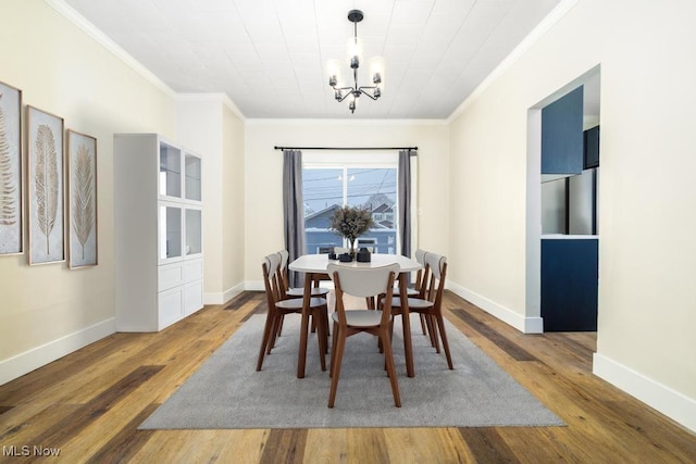 dining room featuring a chandelier, dark hardwood / wood-style flooring, and crown molding