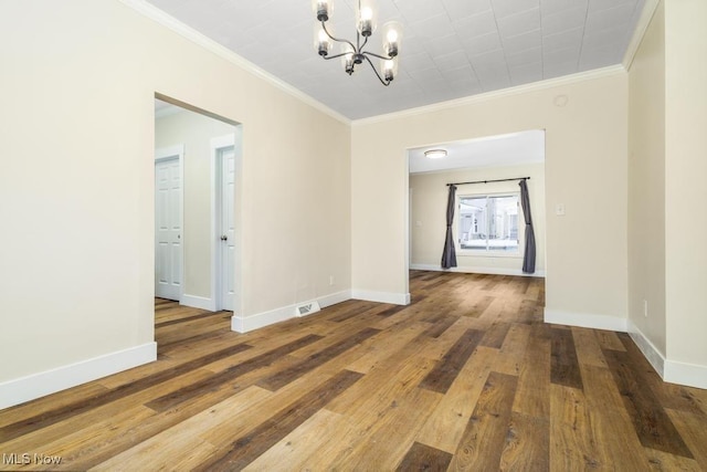 unfurnished room with crown molding, a chandelier, and hardwood / wood-style flooring