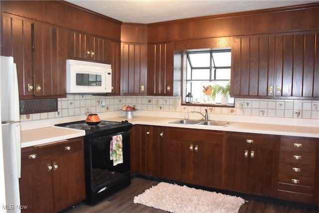 kitchen with dark hardwood / wood-style floors, white appliances, sink, and tasteful backsplash