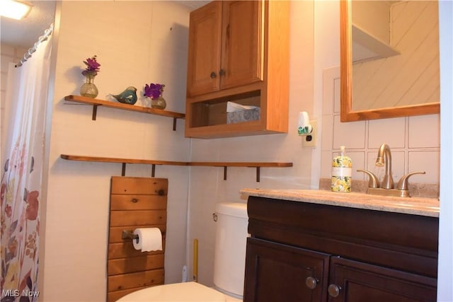 bathroom with backsplash, vanity, and toilet