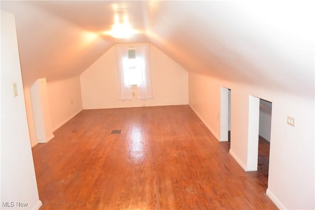 bonus room featuring wood-type flooring and vaulted ceiling