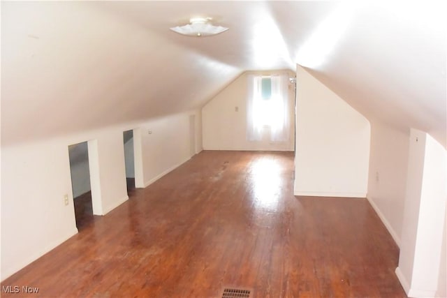 additional living space featuring dark hardwood / wood-style floors and lofted ceiling