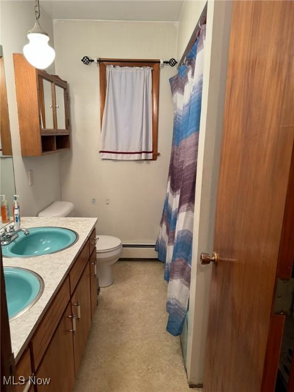 bathroom with a shower with curtain, vanity, toilet, and baseboard heating