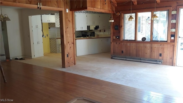 kitchen with light carpet, sink, hanging light fixtures, a baseboard radiator, and a chandelier