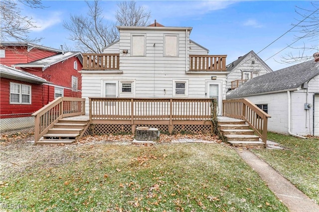 back of property featuring central air condition unit, a lawn, a balcony, and a deck