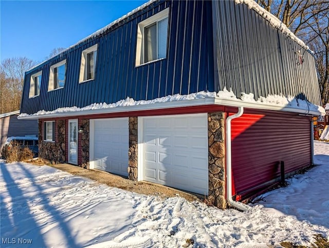 snow covered property featuring a garage