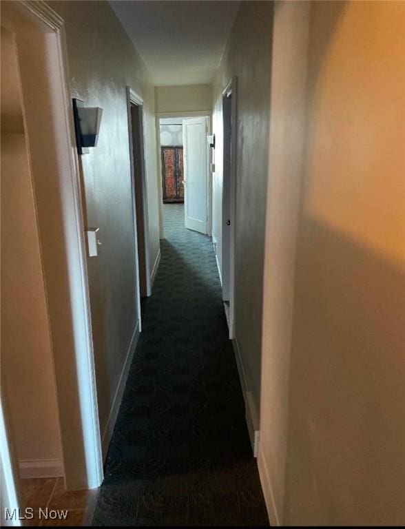 hallway with dark colored carpet