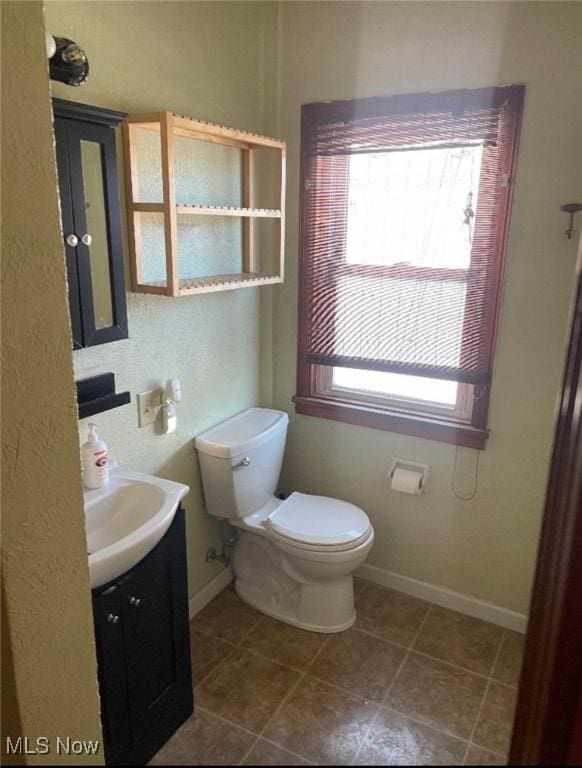 bathroom featuring tile patterned floors, vanity, and toilet