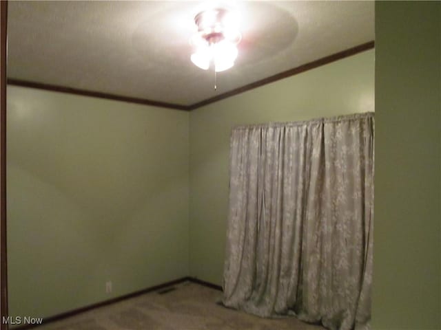 carpeted empty room with baseboards and crown molding