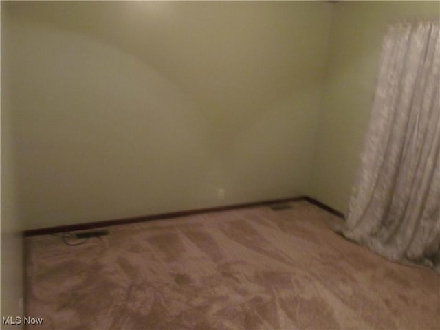 carpeted empty room with baseboards