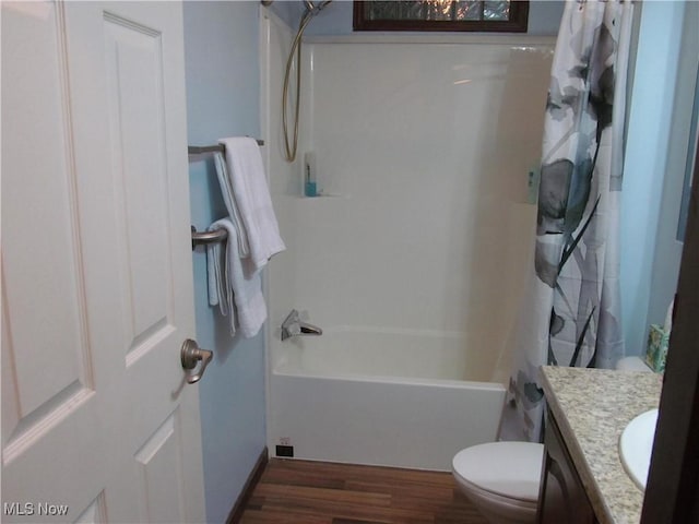 bathroom featuring shower / bathtub combination with curtain, vanity, toilet, and wood finished floors