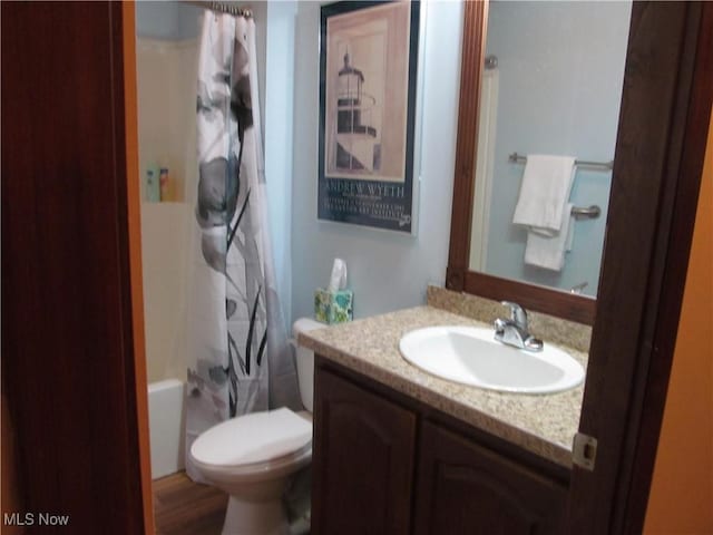 bathroom featuring toilet, shower / bath combination with curtain, and vanity