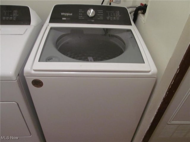 clothes washing area featuring laundry area and washer and clothes dryer