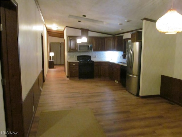 kitchen with stainless steel appliances, a sink, light wood-style floors, hanging light fixtures, and light countertops