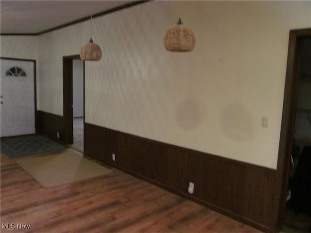 empty room featuring a wainscoted wall and dark wood-type flooring