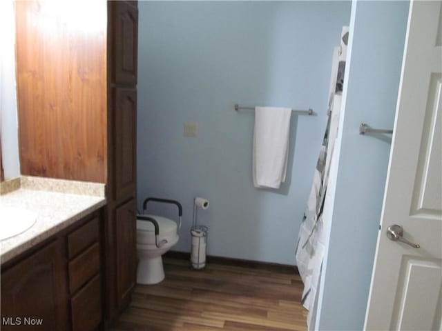 full bath with vanity, toilet, and wood finished floors