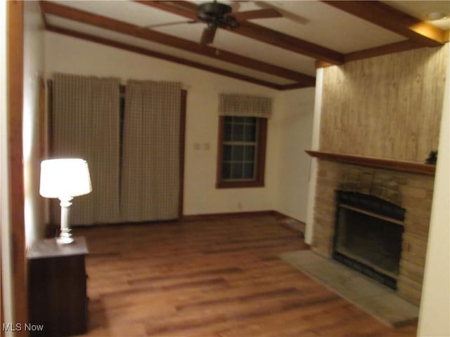 unfurnished living room with vaulted ceiling with beams, ceiling fan, a fireplace, and wood finished floors