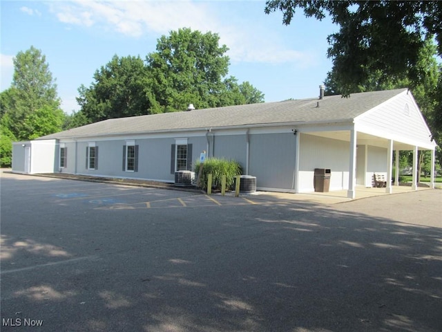 ranch-style house with central air condition unit and uncovered parking