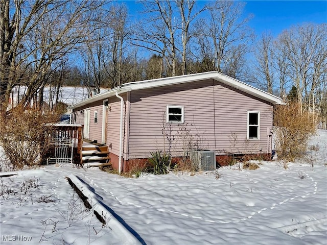 snow covered property featuring cooling unit