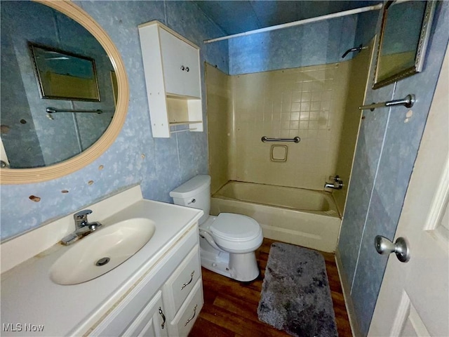 full bathroom featuring vanity, tiled shower / bath combo, hardwood / wood-style flooring, and toilet