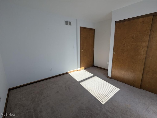 unfurnished bedroom featuring a closet and light carpet